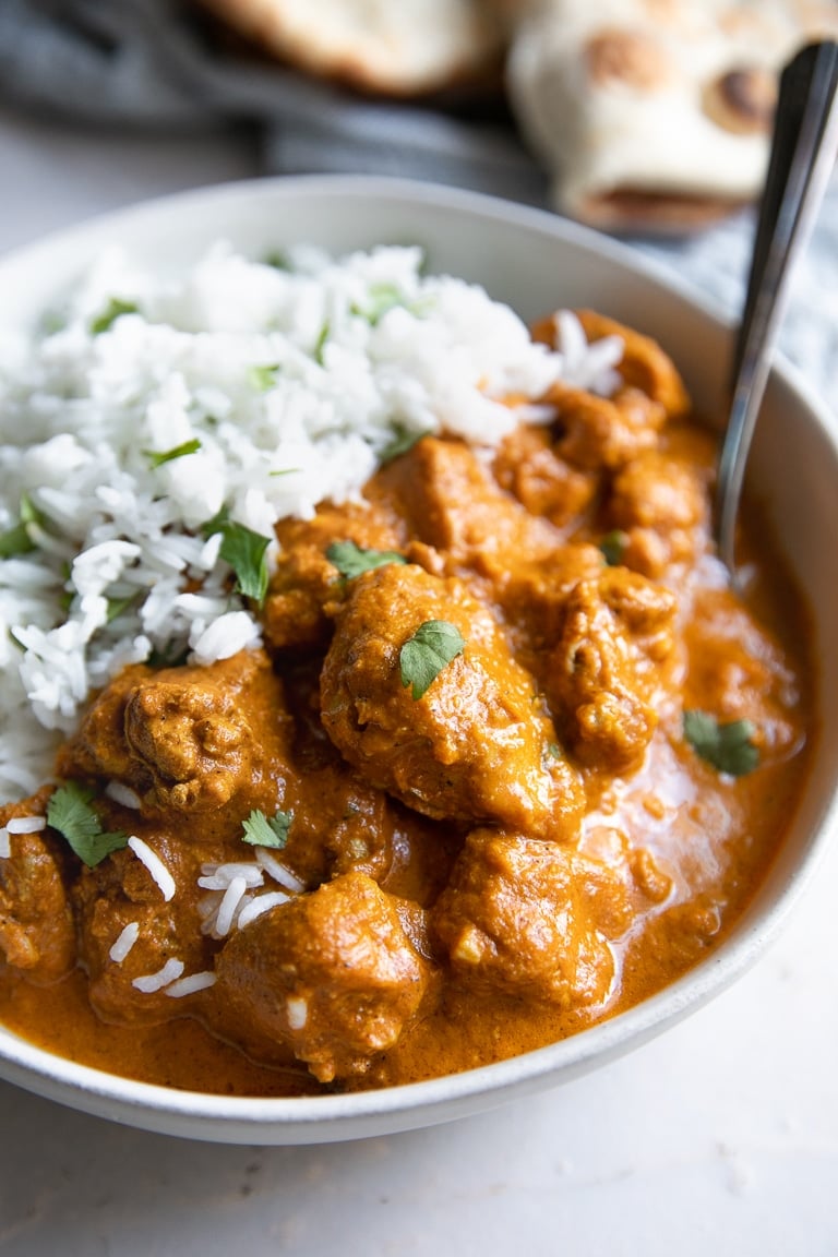 Bowl filled with creamy Chicken Tikka Masala and served with basmati rice.