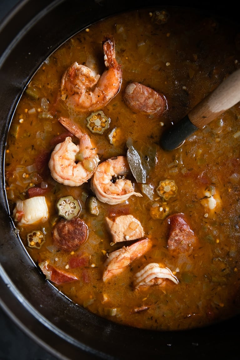 Large cast iron pot filled with chicken, sausage, and seafood filled gumbo recipe.