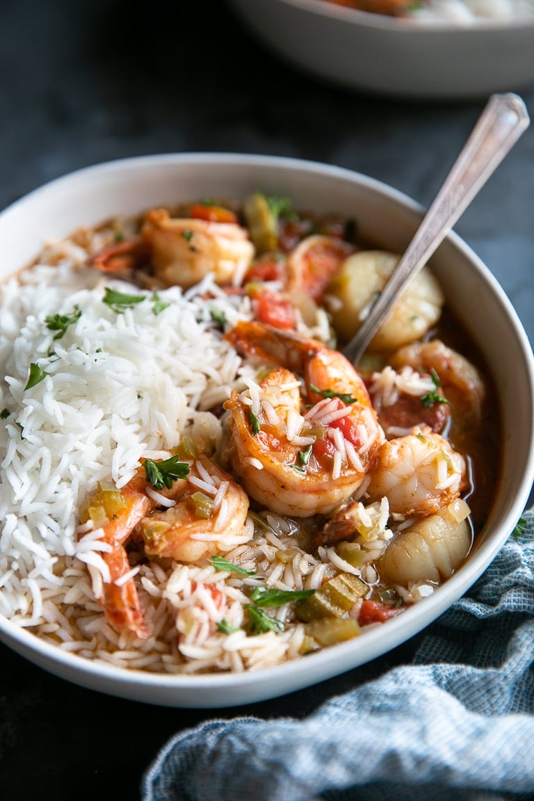 Gumbo mixed with cooked white rice in a white serving bowl.