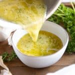 Garlic butter sauce being poured into a bowl from a pan