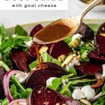 Close-up of roasted beet salad with goat cheese and arugula drizzled with honey balsamic dressing.