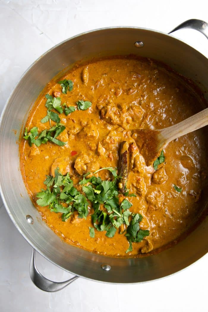 Overhead image of a large pot filled with creamy butter chicken garnished with cilantro ready to be served.