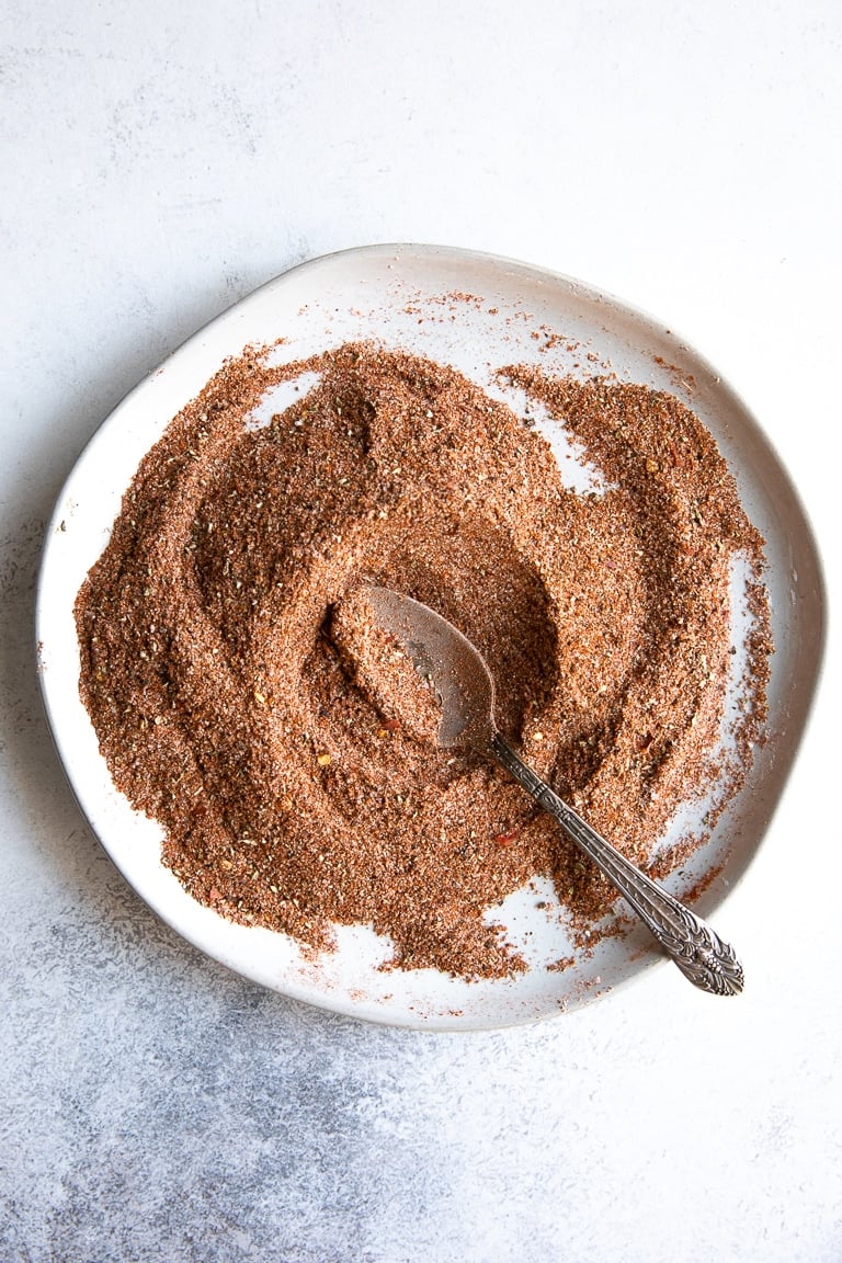 Shallow white plate with mixed up taco seasoning.