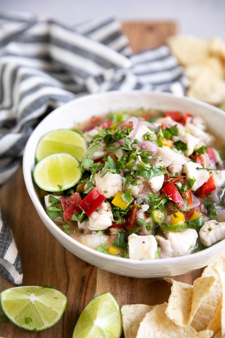 WHite shallow bowl filled with fish ceviche.