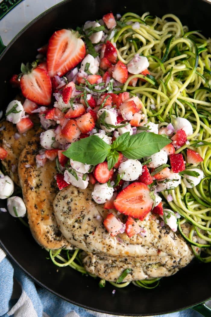 A bowl of salad on a plate, with Chicken and Bruschetta