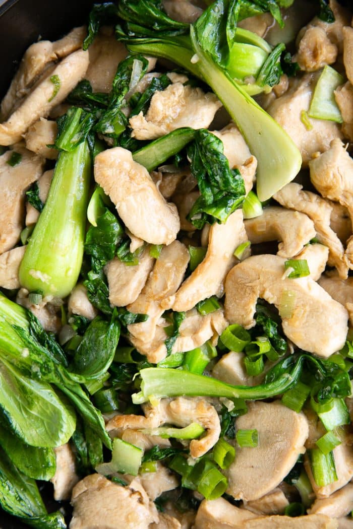 Overhead image of chicken and bok choy stir fried in a light sauce.