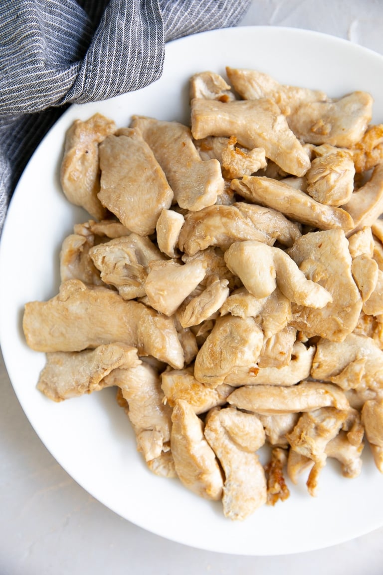 White plate filled with stir fried chicken.