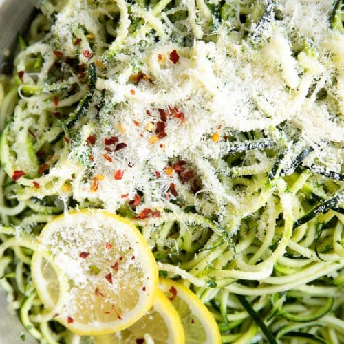 Pan filled with cooked zucchini noodles with parmesan cheese.