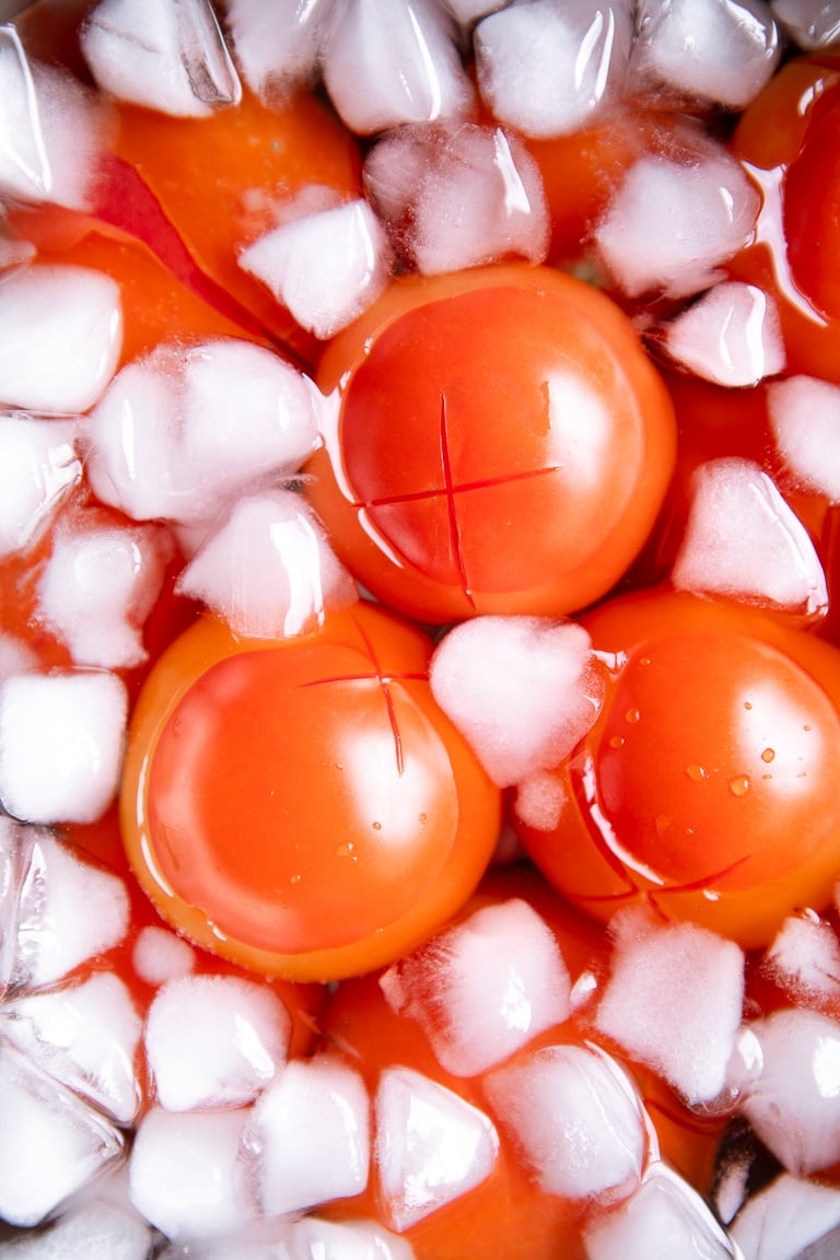 Blanced tomatoes in an ice water bath.