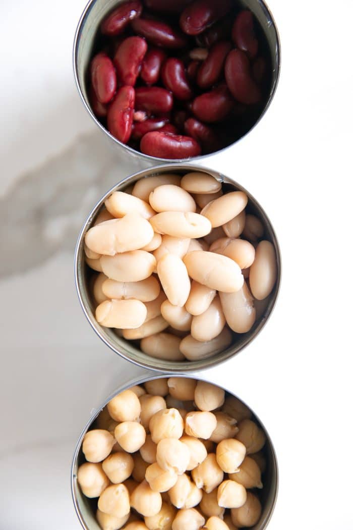Overhead image of three open cans of beans.
