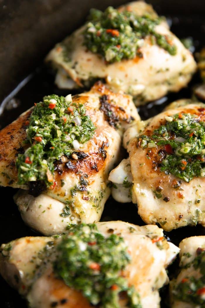 Chimichurri chicken thighs topped with homemade chimichurri sauce.