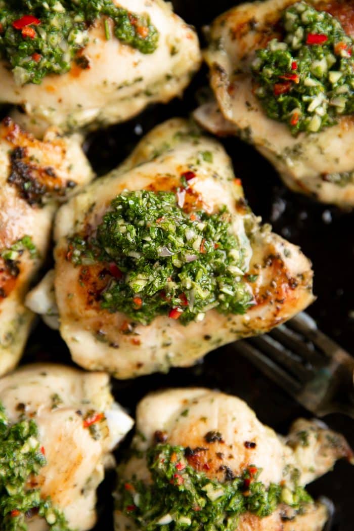 Chimichurri chicken thighs topped with homemade chimichurri sauce.