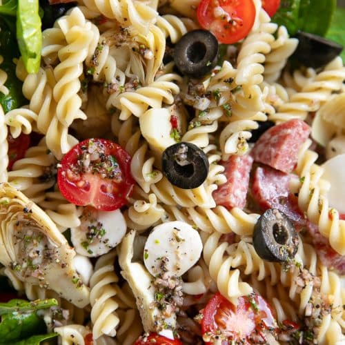 Pasta salad with black olives, salami, spinach, cherry tomatoes, pearl mozzarella.