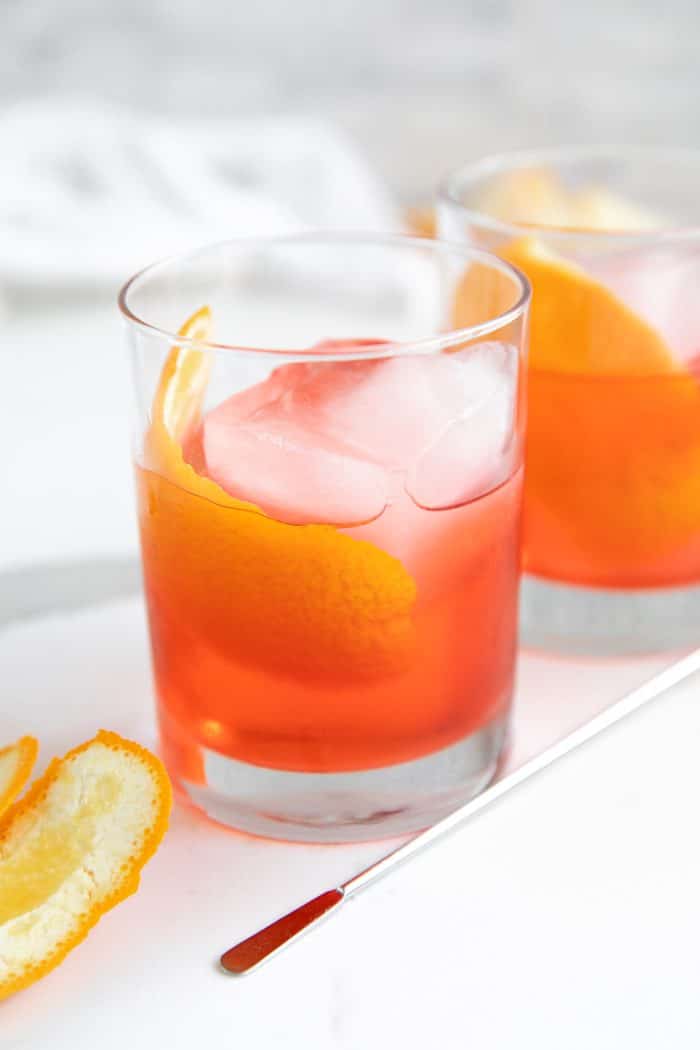 Rocks glass filled with prepared negroni cocktail garnished with an orange slice.