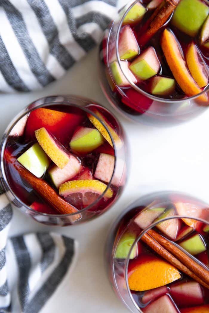 Overhead image of three glasses filled with red wine sangria.