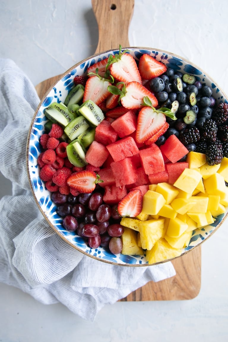 Chopped up chunks of fruit in a large mixing bowl.