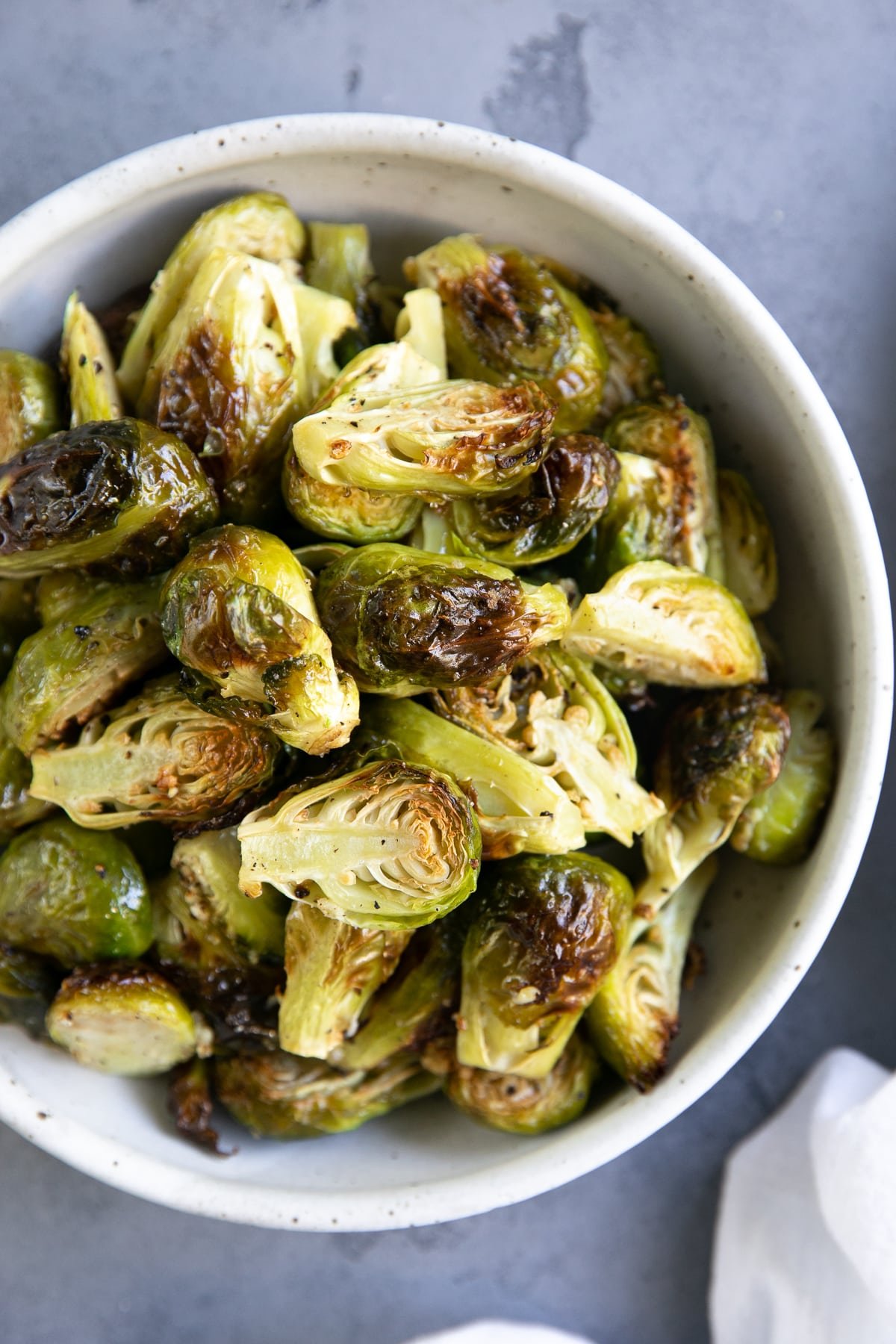 White bowl filled with garlic roasted Brussels sprouts.