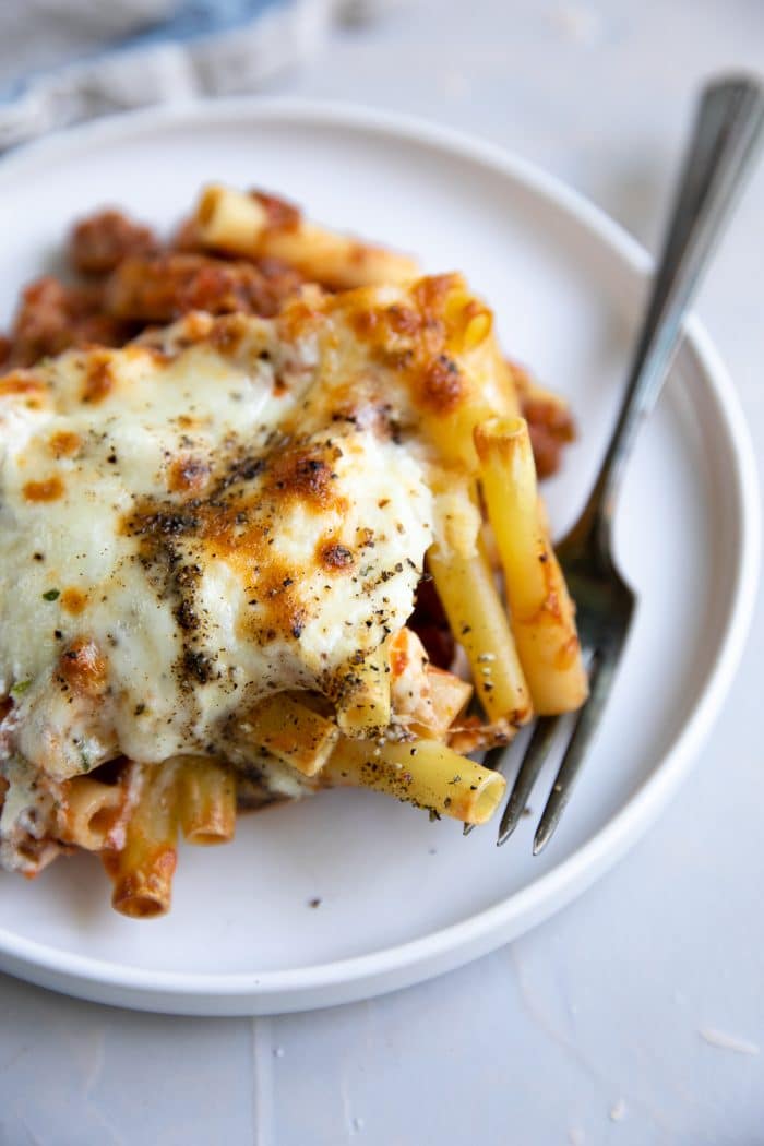 Small serving plate with a single serving of baked ziti.