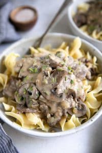 Bowl filled with egg noodles and topped with beef and mushroom stroganoff.