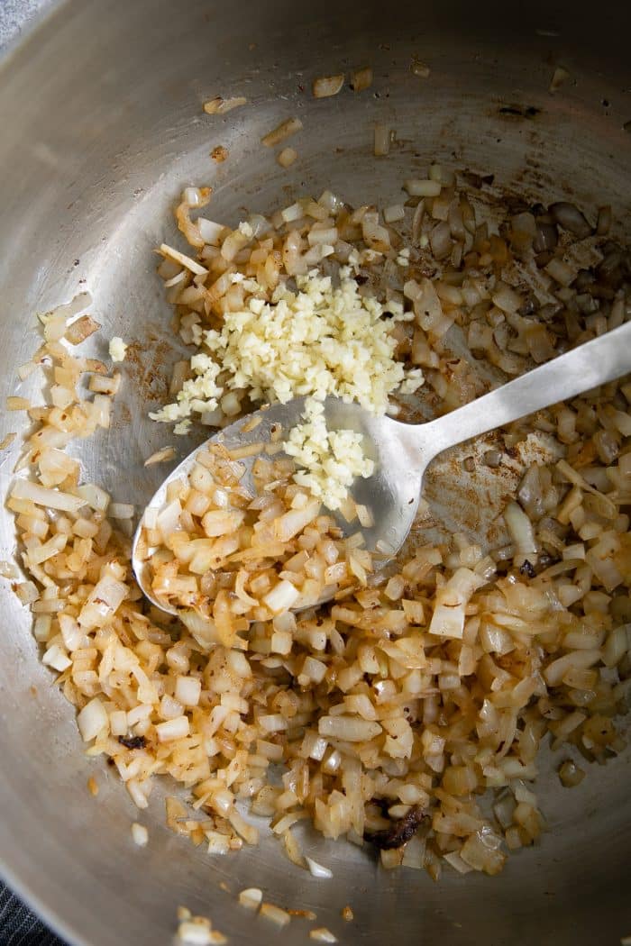 Onions and garlic sauteeing in a large skillet.