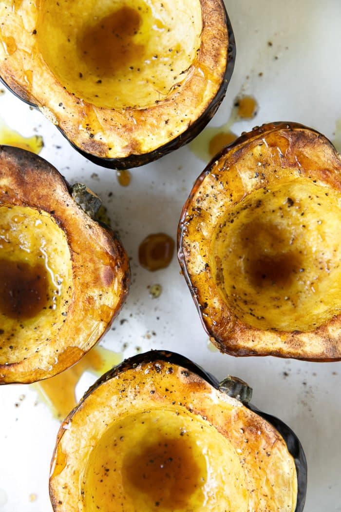 Four roasted acorn squash halves.