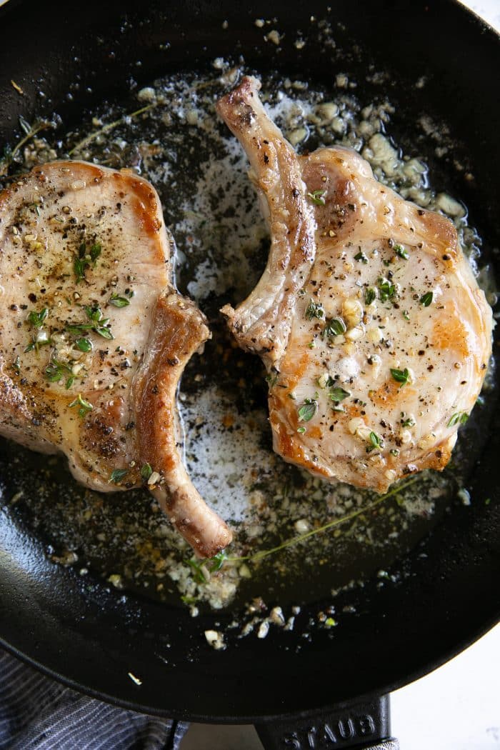 Two cooked bone-in pork chops.