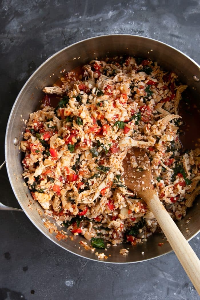 A pot of chicken Caprese Casserole ingredients being mixed