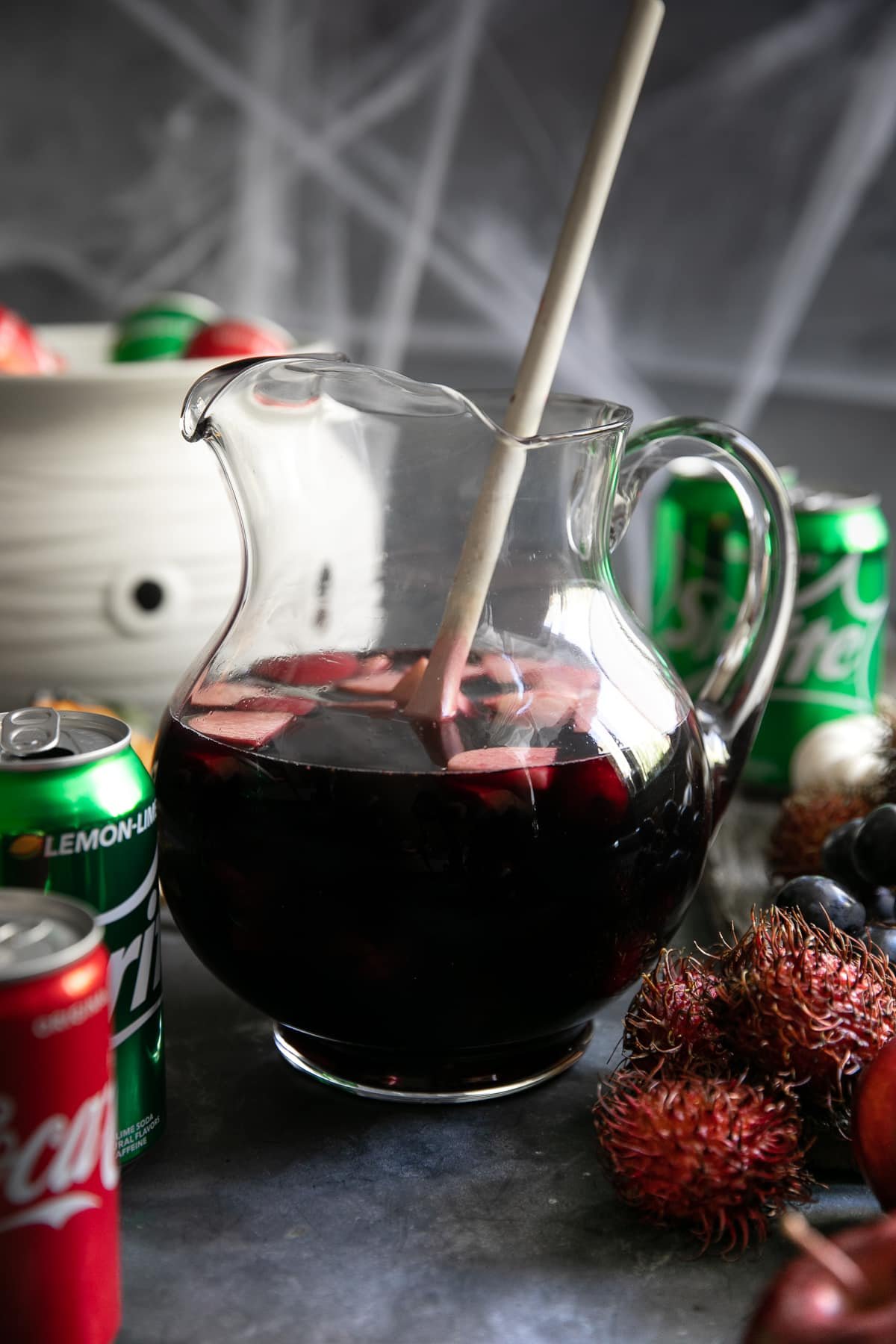 Large pitcher filled with Halloween Sangria made with raspberry liqueur, apple juice, pomegranate juice, vodka, and red wine.