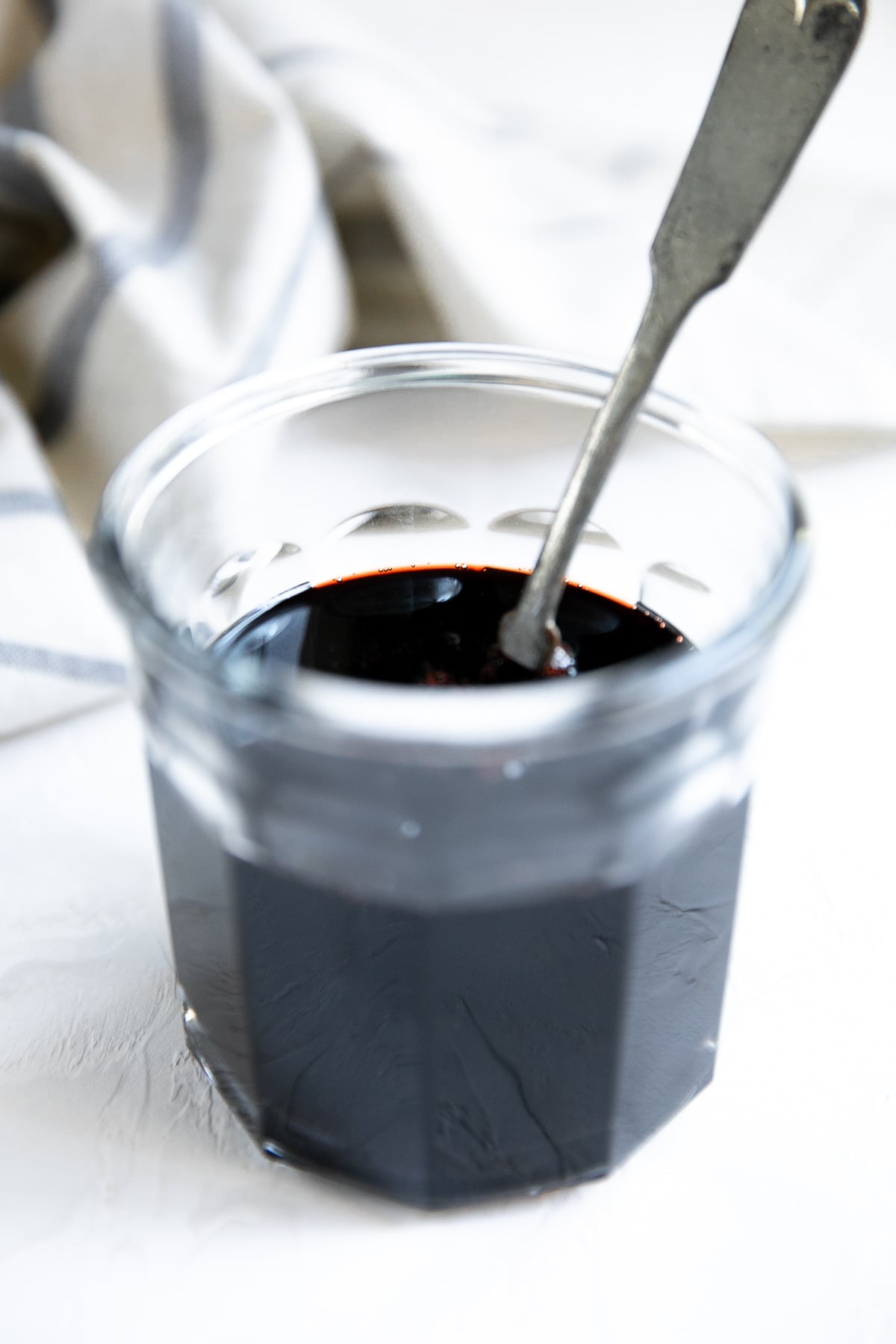 Glass jar filled with syrupy pomegranate molasses.