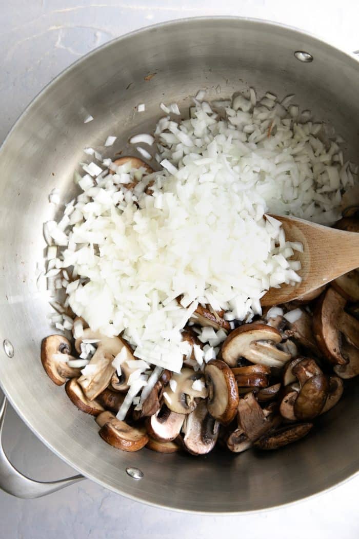 Mushrooms and diced onions in a large pot.