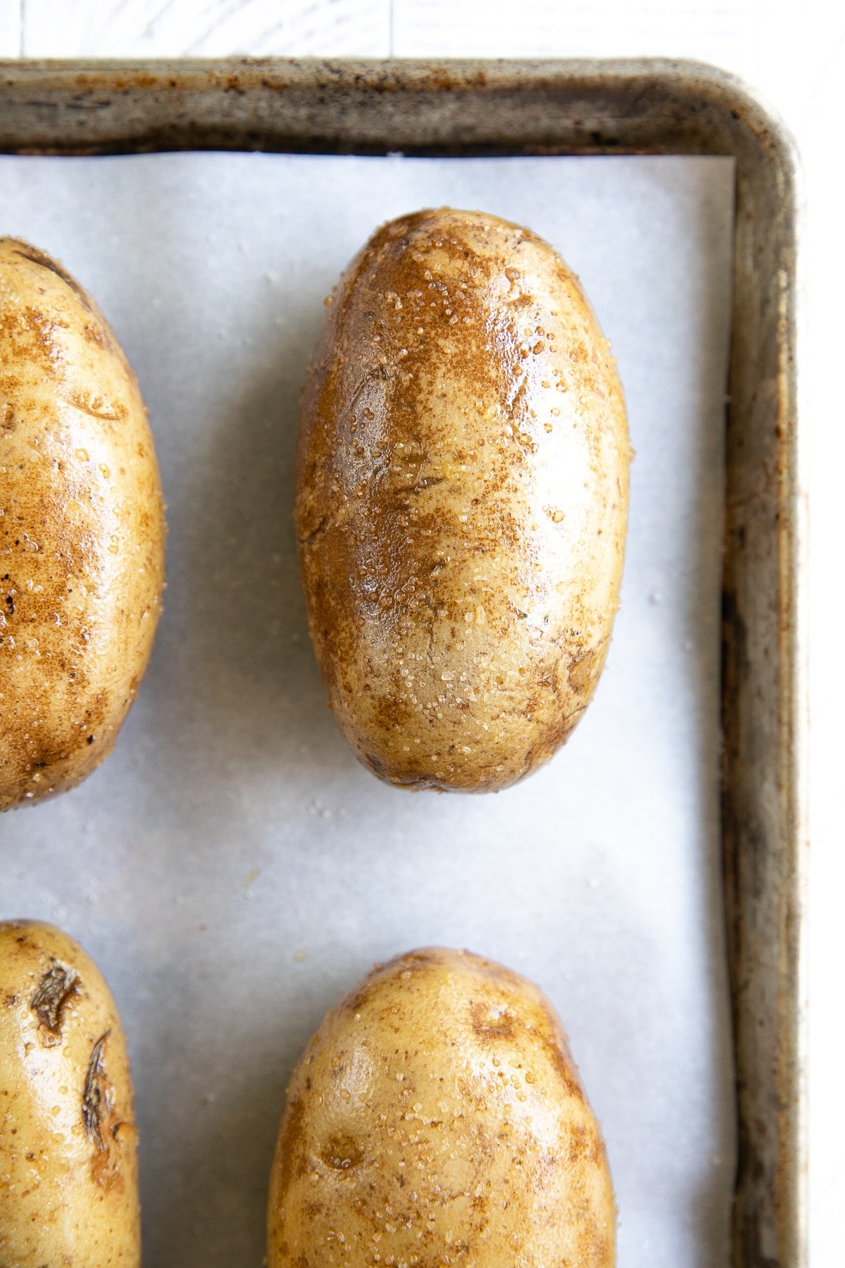 Russet potatoes rubbed with olive oil before baking.
