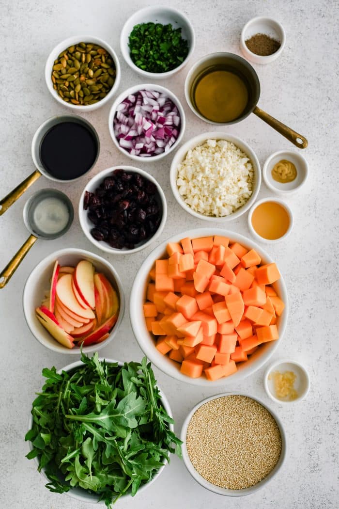 All of the ingredients needed to make butternut squash salad in individual measuring cups and ramekins.