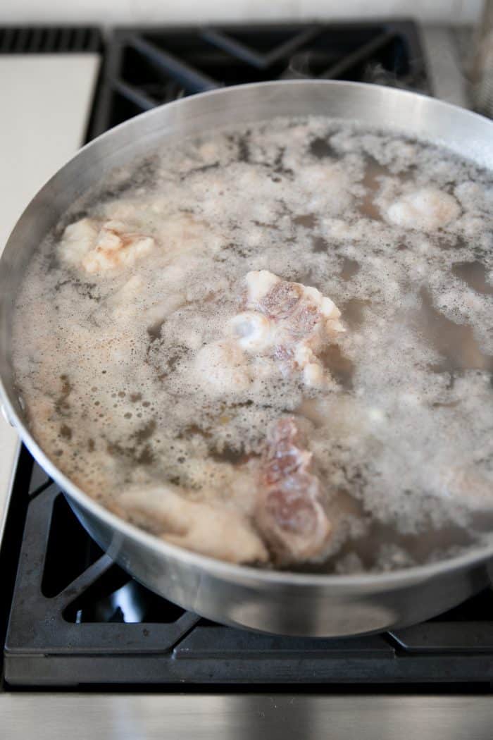 Beef and chicken bones boiling in a large pot.