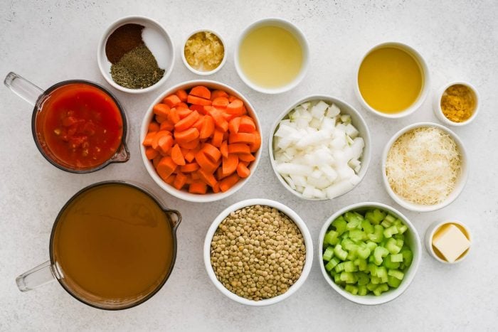 All of the ingredients needed to makelentil soup in individual bowls, measuring cups, and ramekins.