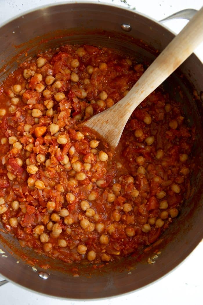 Large pot filled with chickpeas in a rich tomato and pancetta sauce.