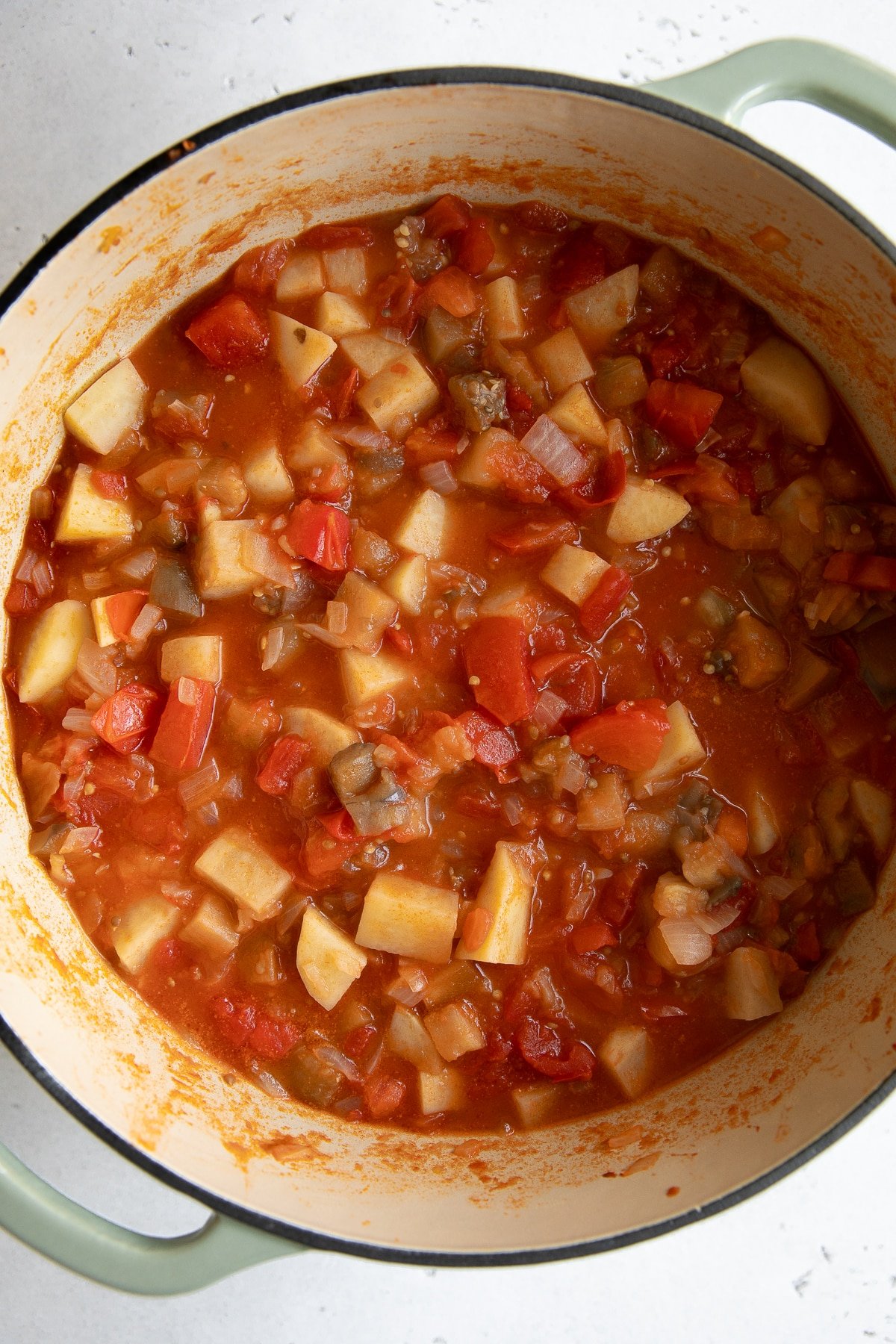 Large pot filled with simmering potatoes, tomatoes, and eggplant.