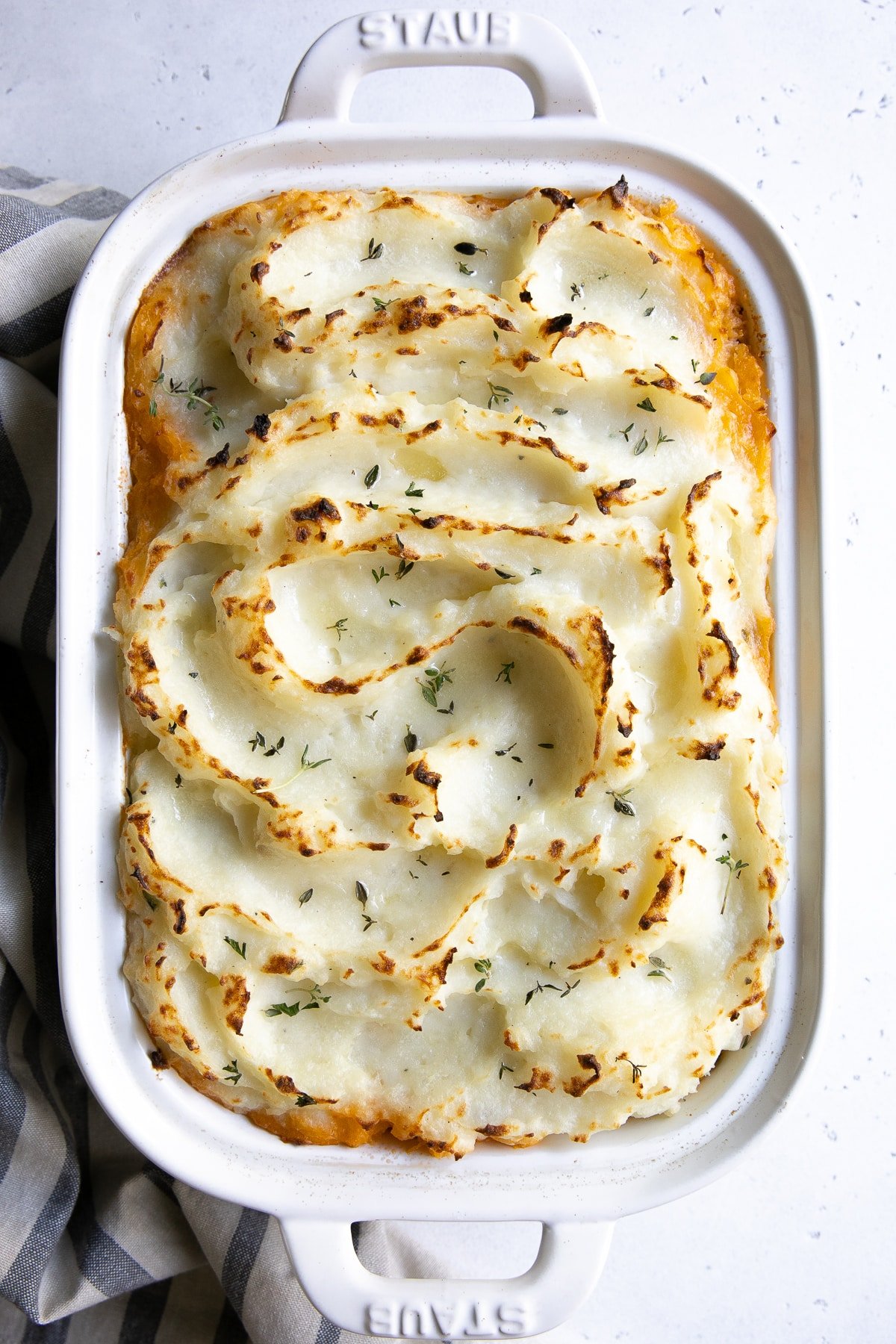 Overhead image of a fully baked Shepherd's pie in a white casserole dish.