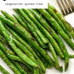 Quick and easy roasted green beans on a white plate with a fork and text overlay
