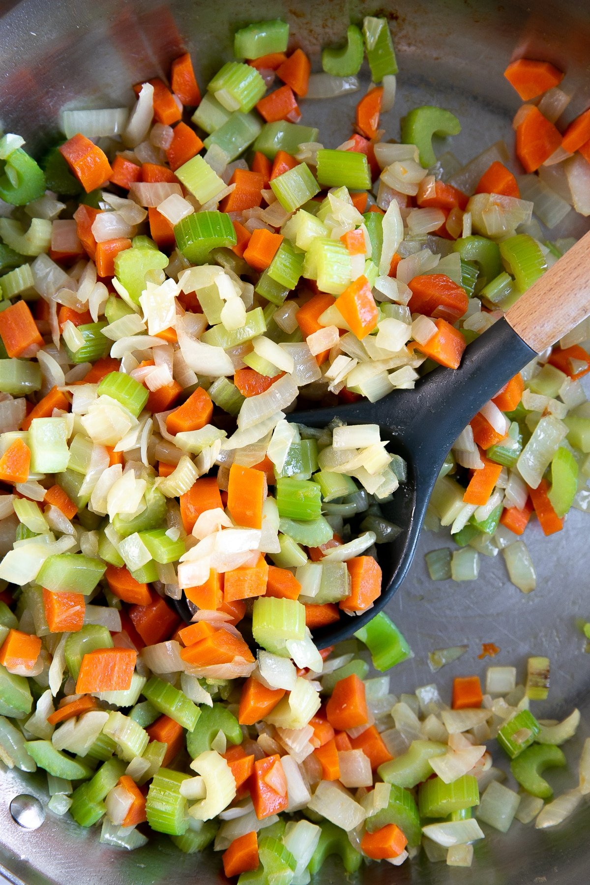 Large skillet filled with finely chopped carrots, celery, and onions.
