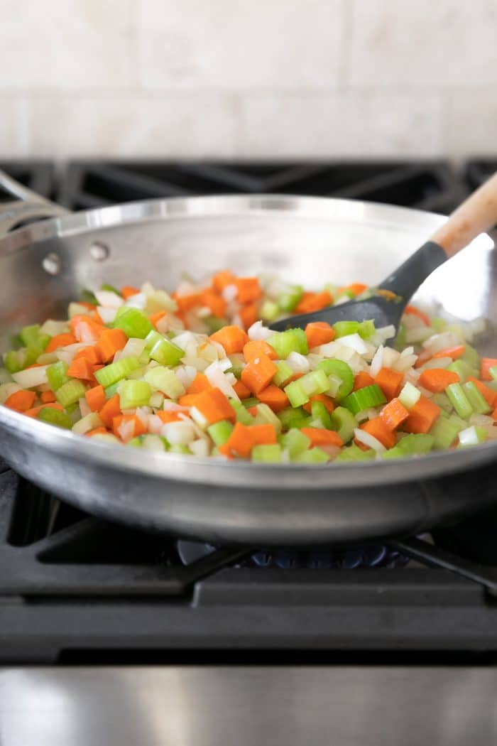 Mirepoix, or finely chopped onions, celery, and carrots, sauteing in a large skillet over medium-high heat.