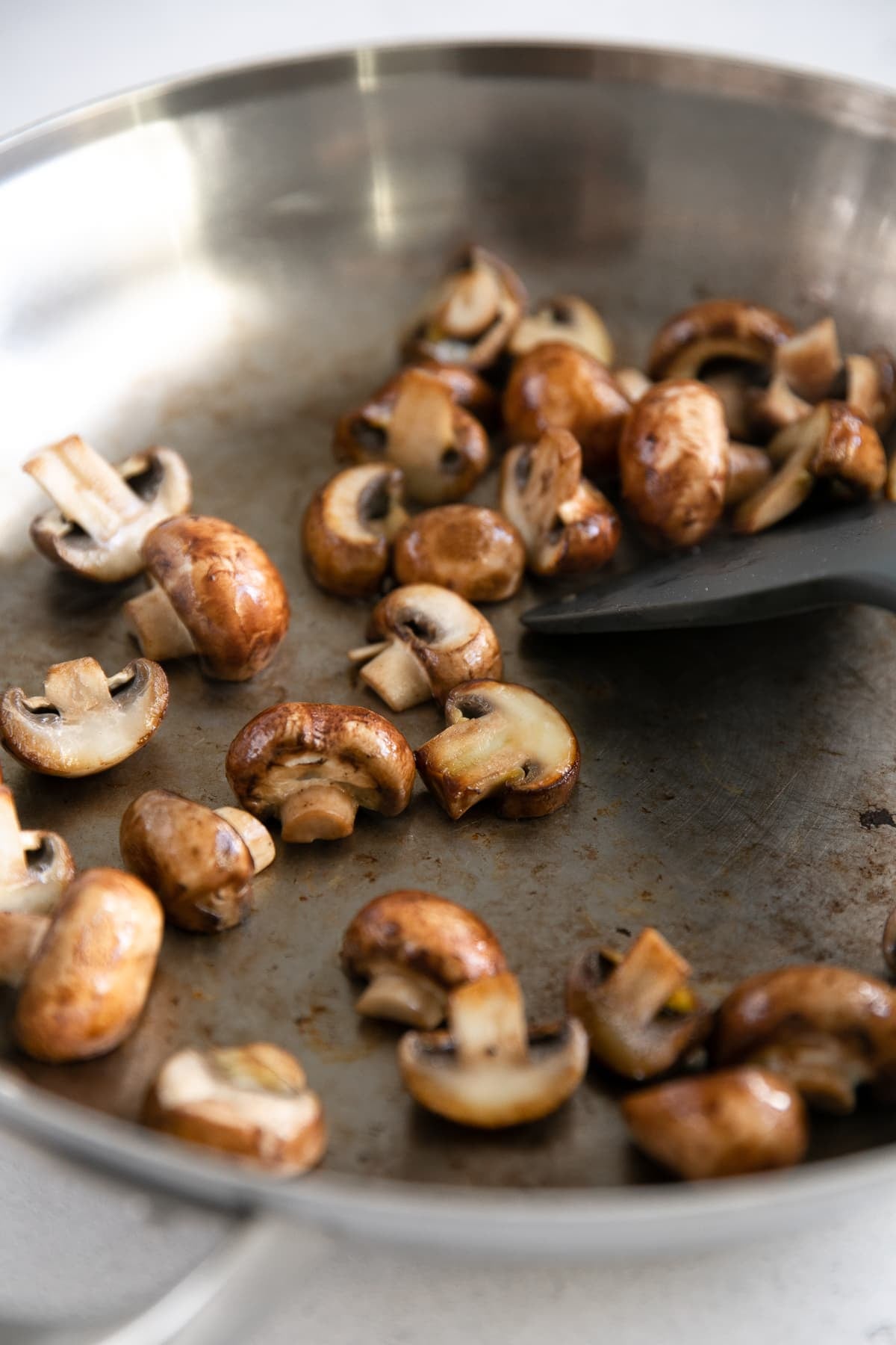 Halved mushrooms in a large skillet.