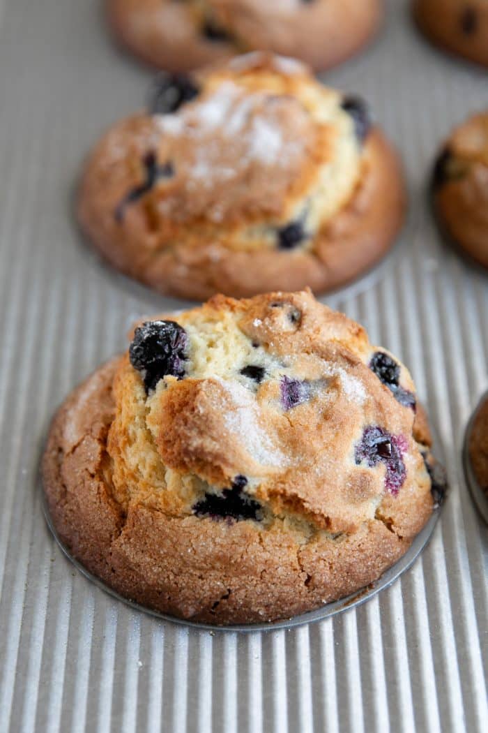 Freshly baked blueberry muffins in a muffin tin.
