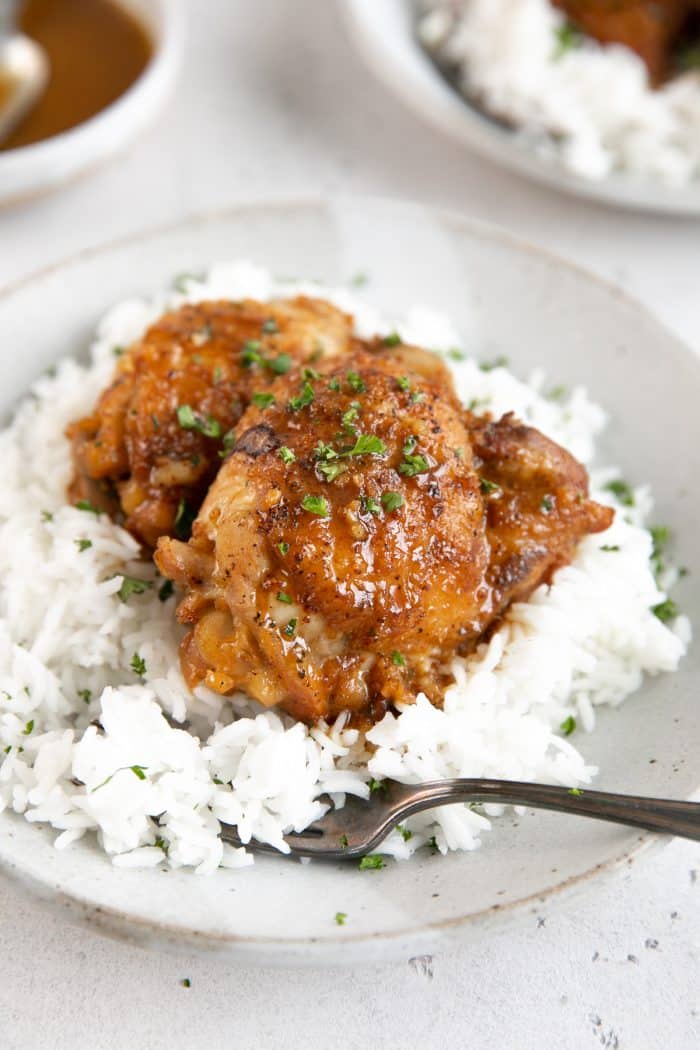 Chicken thighs cooked in the Pressure Cooker in a honey mustard marinade and resting on a bed of white rice.