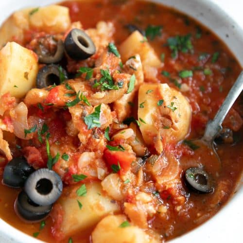 Bacalao made with salted cod, tomatoes, potatoes, shallots, and black olives.