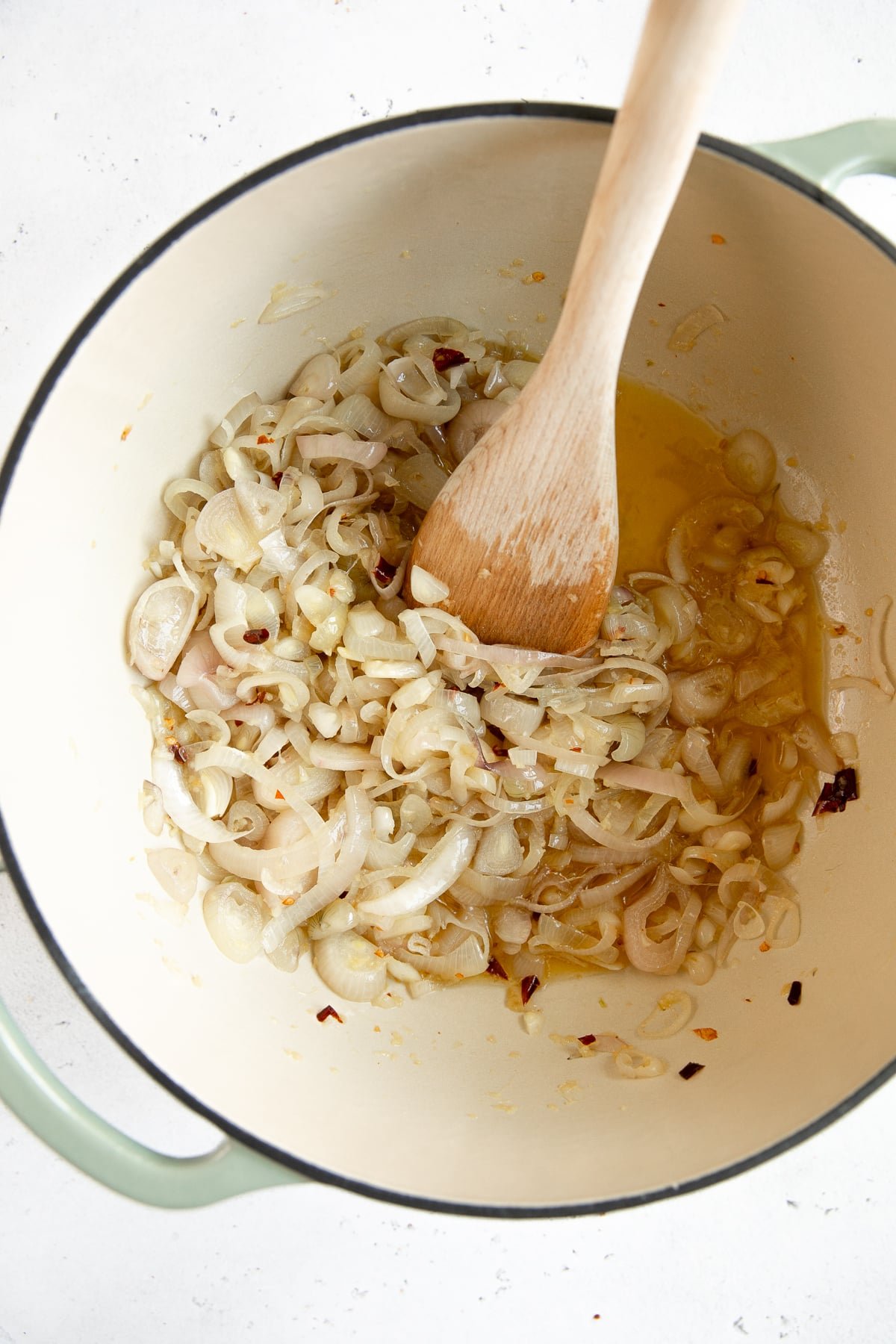Shallots and garlic cooking in a large Dutch oven set over medium-low heat.