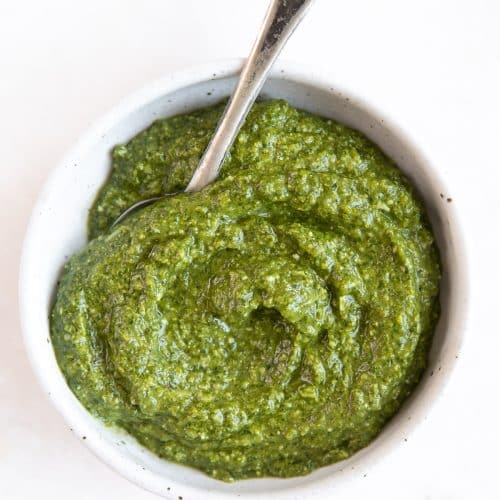 Small white bowl filled with homemade pesto recipe.