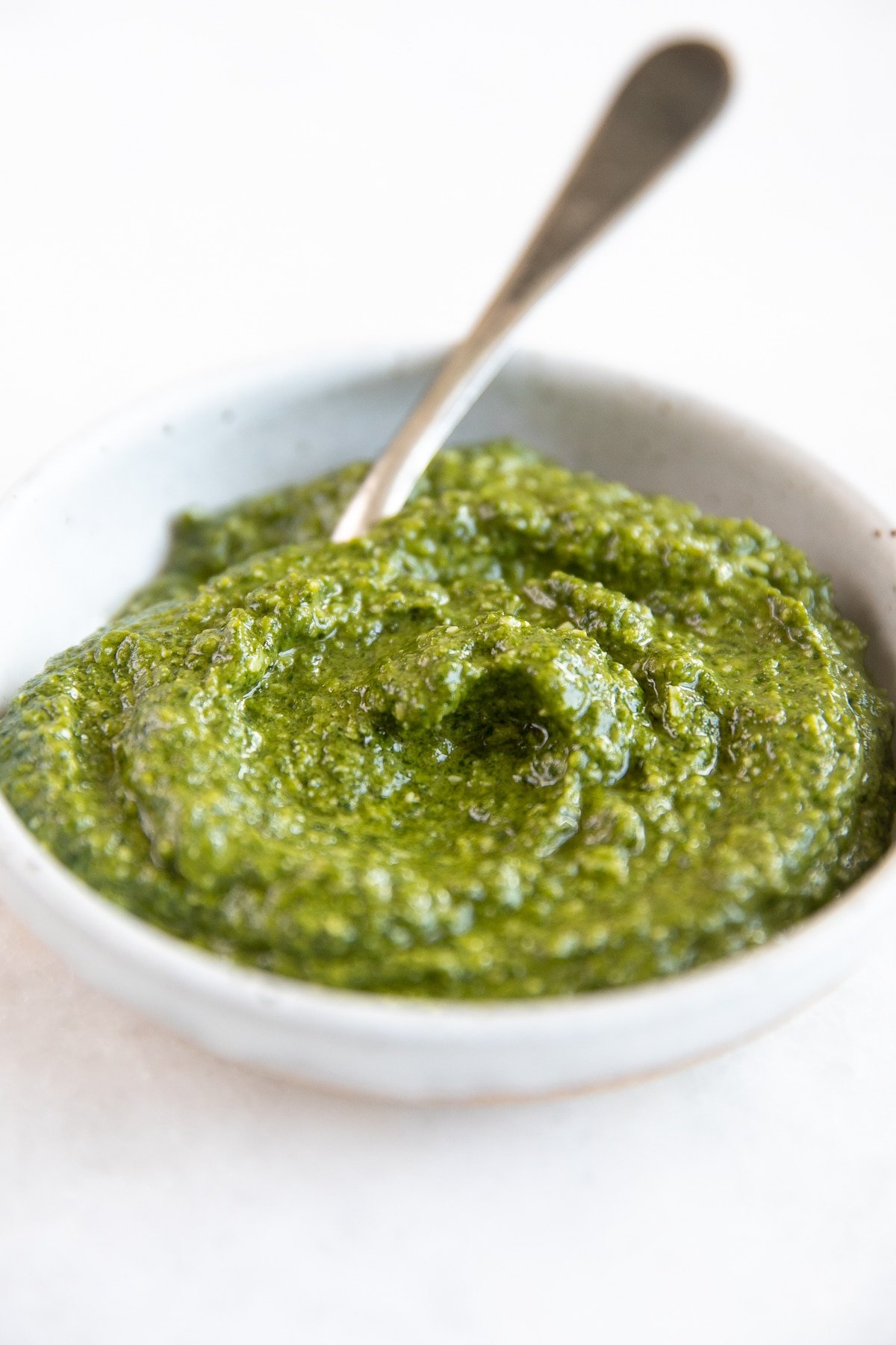 Small bowl filled with pesto basil recipe.