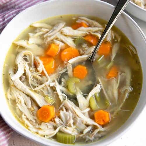 White bowl filled with homemade chicken soup.