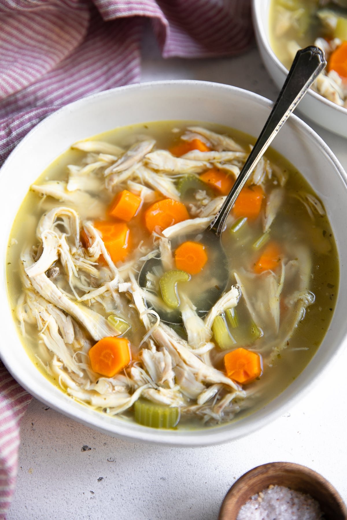 White bowl filled with homemade chicken soup.