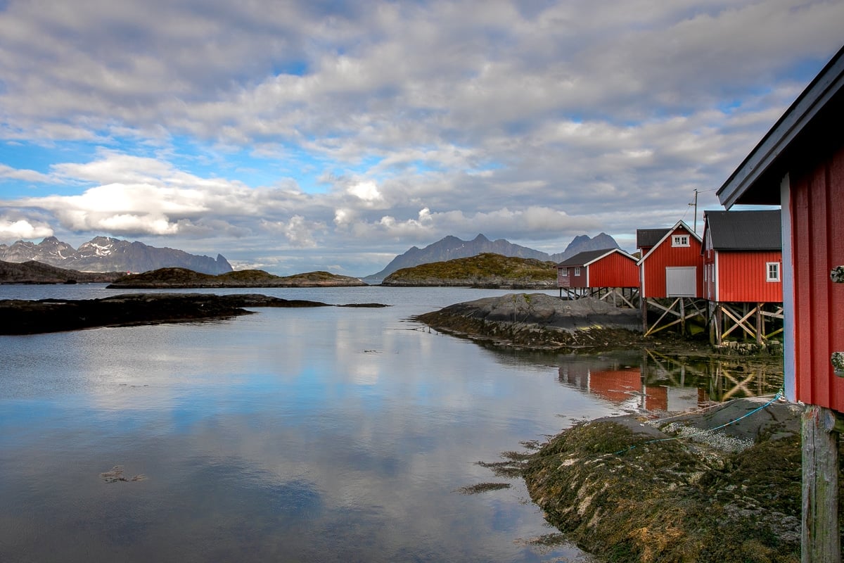 Red Norwegian huts on stilts near a body of water
